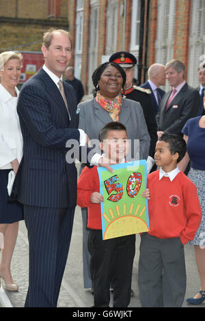 The Earl of Wessex, watched by his wife the Countess of Wessex, is presented with a 50th birthday card by pupils John Lieu, nine, (left) and Pharez Billy, seven, during a visit to Robert Browning Primary School in Walworth, London to see the work of youth charity Kidscape, recipients of grants from the Wessex Youth Trust. Stock Photo