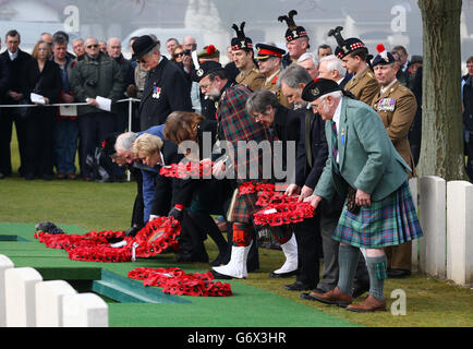 Members of the congregation lay wreaths at graves in the Commonwealth War Graves Commission Loos British Cemetery during of the re-interment of 20 soldiers almost 100 years after they were killed in action in nothern France. Stock Photo