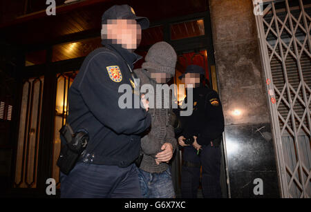 NOTE: IMAGE PIXELATED AT THE REQUEST OF THE POLICE Officers from City of London Police and their Spanish counterparts from the Policia Nacional remove a suspect after raiding a business property in Barcelona, Spain, to execute a warrant in a joint operation as they target a boiler room investment fraud operation. Stock Photo