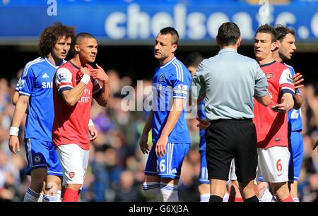 Referee Andre Marriner shows a red card to Arsenal's Kieran Gibbs (left) as he protests his innocence Stock Photo