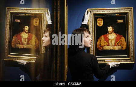 Exhibition administrator Roxanna Hackett is pictured with an Oil anD panel painting, by an anonymous British artist, of James V of Scotland (1512-42) painted around 1540, part of a new Royal Collection exhibition entitled In Fine Style: The Art of Tudor and Stuart Fashion at The Queen's Gallery, Palace of Holyroodhouse, in Edinburgh Scotland. Stock Photo