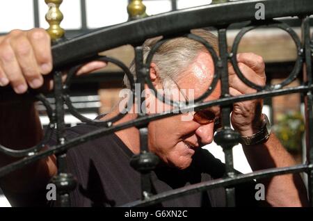 Former football pundit Ron Atkinson looks through the gates of his home at Barnt Green in Worcestershire, after resigning from ITV after an off-air remark about French defender Marcel Desailly was unwittingly broadcast to millions of viewers. Stock Photo