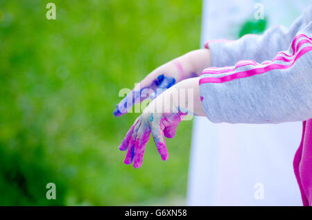 children playing making colorful designs with hands dipped in colored dye Stock Photo