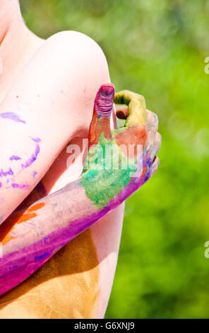 children playing making colorful designs with hands dipped in colored dye Stock Photo