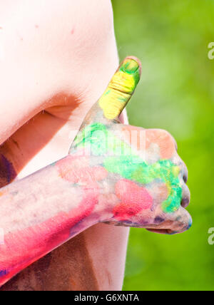 children playing making colorful designs with hands dipped in colored dye Stock Photo