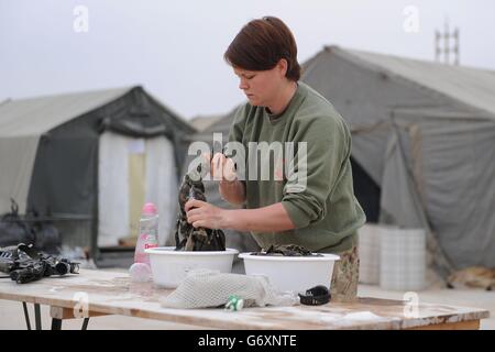 22/02/14 Corporal Samantha Rodway of 220 Signal Squadron hand washing her laundry as conditions have become more austere at MOB Price in Helmand Province ahead of the last British troops leaving the camp. Stock Photo