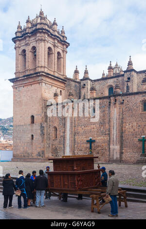 Transportation of a large carved wooden structure outside the Cathedral in Cusco, Peru Stock Photo