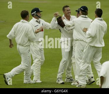 Warwickshire's Dewald Pretorius (centre) celebrates taking the wicket of Surrey opener Scott Newman who was caught behind by wicketkeeper Tony Frost (3rd right) during the second day of their County Championship division one match at Edgbaston, Birmingham. Stock Photo