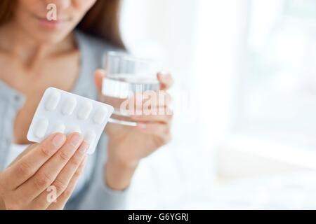 MODEL RELEASED. Young woman holding blister pack. Stock Photo