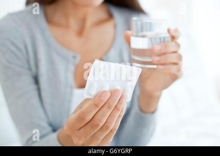 MODEL RELEASED. Young woman holding blister pack. Stock Photo