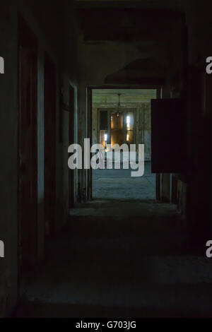 Empty chair in deserted room of Ellis Island down dark hallway. Stock Photo
