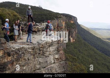 The Duke of Cambridge (centre) looks over the edge of a cliff as he and the Duchess of Cambridge visit the Narrow Neck Lookout and observes abseiling by the Mountain Youth Services group in the Blue Mountains town of Katoomba, west of Sydney. Stock Photo