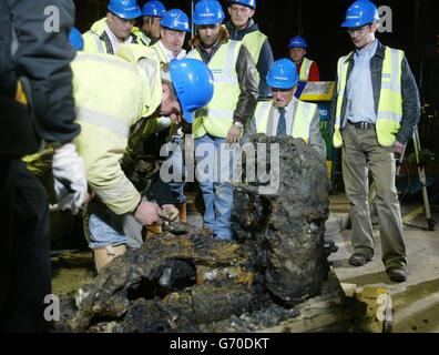 Second World War pilot Sergeant Ray Holmes (2nd R), looks at the engine block of his Hurricane fighter plane which was dug up on Buckingham Palace Road , at the juction of Ebury Bridge Road where it crashed after a dog fight with a German bomber plane over Victotria in 1940. The live Channel Five TV show, Fighter Plane Dig ... Live, told the story. Stock Photo