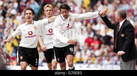 Manchester United's Ruud Van Nistelrooy (centre) celebrates scoring his second goal agains't Aston Villa with Gary Neville (far left) and Manager Alex Ferguson, during their Barclaycard Premiership match at Villa Park, Birmingham Saturday May 15 2004. Stock Photo