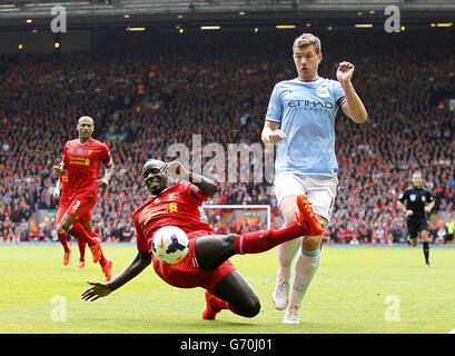 Manchester City's Edin Dzeko (right) and Liverpool's Mamadou Sakho battle for the ball during the Barclays Premier League match at Anfield, Liverpool. Stock Photo