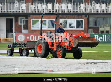 Ground staff tend to the covers as the start of play is delayed during the LV County Championship, Division Two match at The 3aaa County Ground, Derby. Stock Photo