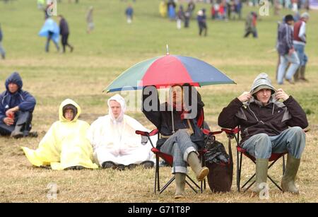 Glastonbury 2004. Spectators braving the rain during the Glastonbury Festival, held at Worthy Farm in Pilton, Somerset. Stock Photo