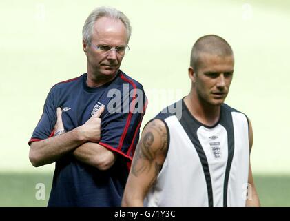 England coach Sven-Goran Eriksson (left) keeps an eye on David Beckham during a training at the National Stadium in Lisbon, Portugal, Saturday June 12, 2004 in preparation for the Euro 2004 championship opening match against France tomorrow. 03/10/04: Eriksson has reaffirmed that David Beckham will remain England captain. Reports suggested Manchester United defender Rio Ferdinand could lead his country 'in the future'. But Eriksson told Sky Sports that Real Madrid midfielder Beckham will carry on as England's captain on the pitch. He said: I have no intention of changing the captain - not Stock Photo