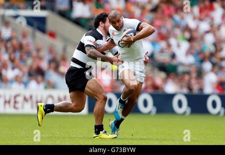 Rugby Union - International Friendly - England XV v Barbarians - Twickenham. England's Jonathan Joseph is tackled by Barbarians Anthony Tuitavake during the International Friendly match at Twickenham Stadium, London. Stock Photo