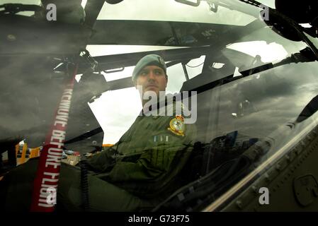 Captain Richard Youngs of 673 Squadron Army Air Corps checks over his newly delivered Apache AH Mk1 attack helicopter at the Farnborough International Airshow in Hampshire. Stock Photo