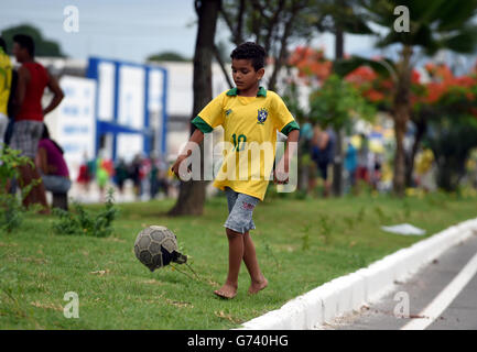 Soccer - FIFA World Cup 2014 - Group A - Brazil v Mexico - Estadio Castelao. A Young Brazil fan plays football on the streets of Fortaleza Stock Photo