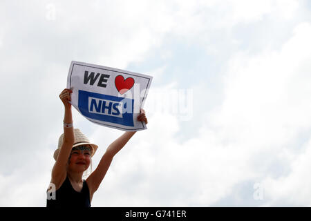 A young girl holds a We heart NHS sign in the crowds during the The Lewisham and Greenwich NHS Choir performance on The Pyramid Stage at the Glastonbury Festival, at Worthy Farm in Somerset. Stock Photo