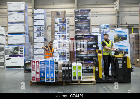 Pawel Majdek (left) and Stuart Berry, packers at Currys and PC World's distribution centre in Newark, work on delivery fulfilment as the demand for televisions, ahead of this year's summer of sport, has increased due to the retailer's Cash for Goals promotion. Stock Photo