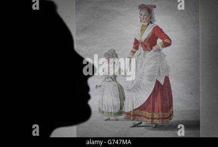 Scottish National Gallery employee Laura Oakley is silhouetted with a work titled A Young Woman (Rosalina Scala) with her Daughter in Traditional Neapolitan Dress, by artist Giovanni Battista Lusieri from the First Sight exhibition at the Scottish National Gallery in Edinburgh, Scotland. Stock Photo