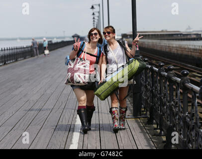 Isle of Wight Festival 2014 - Day 1. Festival goers walking along Ryde pier, Isle of Wight as they arrive for the Isle of Wight Festival. Stock Photo