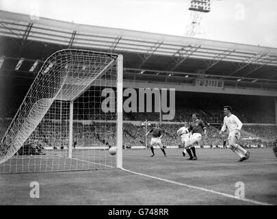 Manchester United centre-forward David Herd (dark shirt second from right), the scorer, gives a cry of triumph as the ball crosses the Leicester City goalline for United's second goal in the FA Cup Final at Wembley. Manchester United won 3-1. Stock Photo