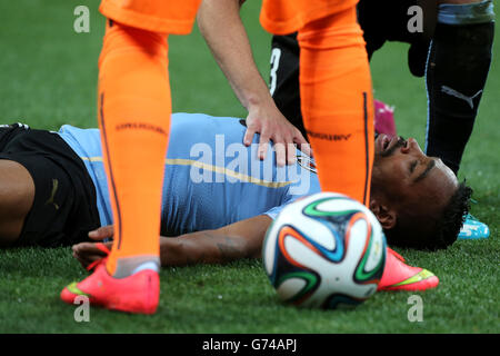 Uruguay's Alvaro Pereira (right) after a coming together with England's Raheem Sterling during the Group D match the Estadio do Sao Paulo, Sao Paulo, Brazil. Stock Photo