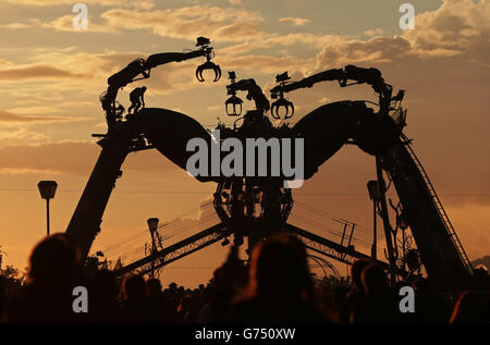 The giant mechanical spider at Arcadia is silhouette at sunset at the Glastonbury Festival, at Worthy Farm in Somerset. Stock Photo