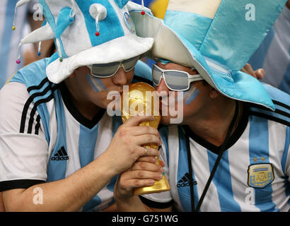 Soccer - FIFA World Cup 2014 - Group F - Argentina v Bosnia and Herzegovina - Maracana. Argentina fans kiss a replica of the world cup trophy in the stands sunglasses Stock Photo