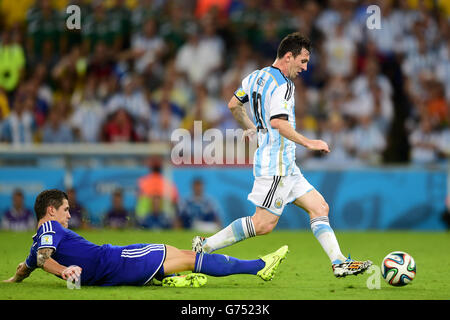 Soccer - FIFA World Cup 2014 - Group F - Argentina v Bosnia and Herzegovina - Maracana. Argentina's Lionel Messi skips away from Bosnia-Herzegovina's Muhamed Besic (left) Stock Photo