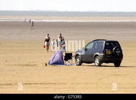 Sun bathers on Middleton Sands at Morecambe Bay in Lancashire where more than a 100 cocklers was rescued after being stranded four miles from shore vans when two tractor units pulling the trailers on which they were being carried, collided at around 10am. Stock Photo