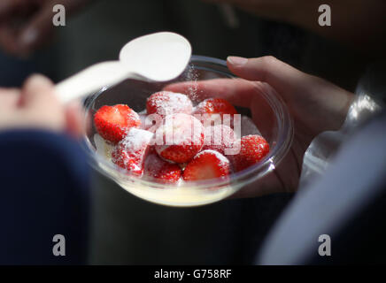 A spectator holding strawberries and cream during day three of the Wimbledon Championships at the All England Lawn Tennis and Croquet Club, Wimbledon. Stock Photo