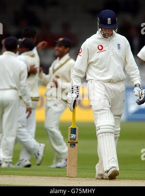 Members of the Sri Lankan team celebrate in the background as England's Marcus Trescothick walks back to the pavilion after being caught by Sanath Jayasuriya off the bowling of Nuwan Zoysa for 13 runs during the second day of the first test match at Lord's cricket ground, London. Stock Photo