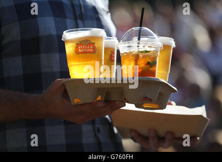 A spectator carries drinks on Murray mount watching Andy Murray playing on day five of the Wimbledon Championships at the All England Lawn Tennis and Croquet Club, Wimbledon. Stock Photo