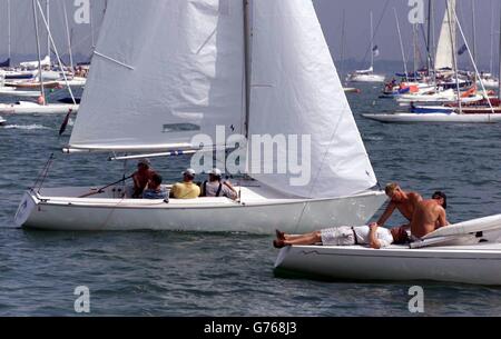 Yachts left stranded without any wind in Cowes Haven on the Isle of Wight the third day of the Cowes Week sailing regatta. Racing was postponed due to lack of wind, leaving 890 boats and 8,000 sailors becalmed in the harbour. Stock Photo