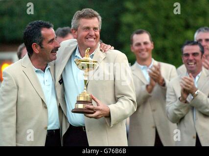 European captain Sam Torrance (left) with Colin Montgomerie holding the Ryder Cup trophy applauded by Niclas Fasth and Paul McGinley (right) after winning the 34th Ryder Cup against USA at the Belfry, near Sutton Coldfield. Stock Photo