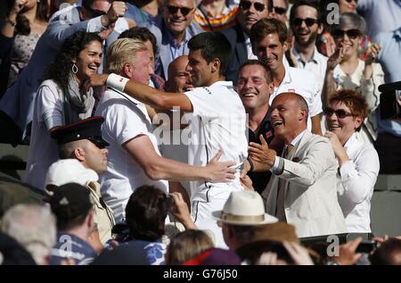 Serbia's Novak Djokovic celebrates defeating Switzerland's Roger Federer with his coach Boris Becker in the players box, following the Mens' Singles Final during day fourteen of the Wimbledon Championships at the All England Lawn Tennis and Croquet Club, Wimbledon. Stock Photo