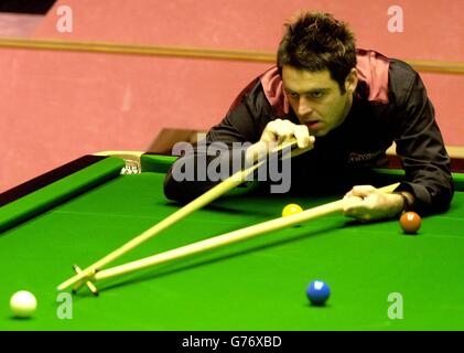 England's Ronnie O'Sullivan uses a rest during the quarter-final match of the Embassy World Snooker Championships against England's Stephen Lee at the Crucible. Stock Photo