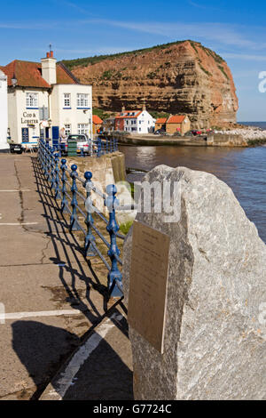 UK, England, Yorkshire, Staithes, High Street, seafront flood defences plaque beside harbour Stock Photo