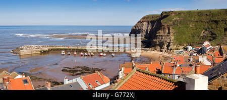 UK, England, Yorkshire, Staithes, elevated panoramic view of village rooftops and harbour Stock Photo