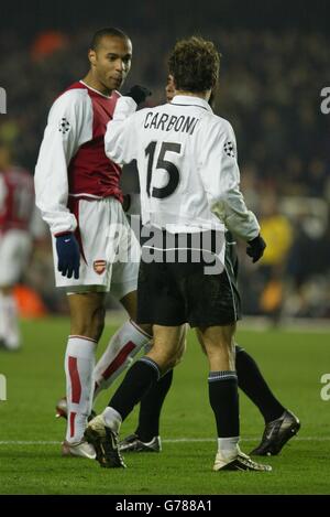 The match referee steps between Arsenal's Thierry Henry (left) and Valencia's Amedoe Carboni, after a clash between the two players, during their Champions League match at Highbury in North London. NO PUBLICATION ON ANY INTERNET SITE DURING MATCH (INCLUDING HALF TIME, EXTRA TIME AND PENALTY SHOOT-OUTS). Stock Photo