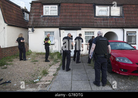 Home Office Immigration Enforcement officers prepare to raid a property to detain suspected illegal immigrants in Slough, Berkshire. Stock Photo