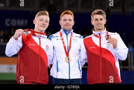 (left to right) Silver medalist England's Nile Wilson, gold medalist Scotland's Daniel Purvis and bronze medalist England's Max Whitlock after the Men's Parallel Bars Final, at the SSE Hydro, during the 2014 Commonwealth Games in Glasgow. Stock Photo