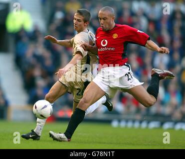 Manchester United's Mikael Silvestre (right) challenges Portsmouth's Gary O'Neill for the ball during their FA Cup Third Round match at Manchester United's Old Trafford ground. Manchester United defeated Portsmouth 4-1. Stock Photo