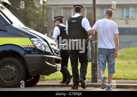 A suspect is led away as City of London Police execute a warrant at an address in Peckham, London, in connection with a criminal ring linking Russian hackers and ID thieves with ticket resellers in New York and money-launderers in the United Kingdom and Canada. Stock Photo