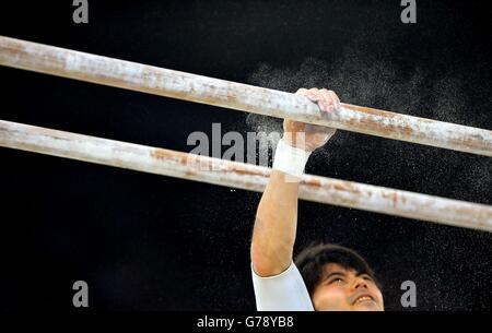 Australia's Naoya Tsukahara applies chalk to the parallel bars as he competes in the Men's Artistic Gymnastics All-Around Final at the SSE Hydro, during the 2014 Commonwealth Games in Glasgow.